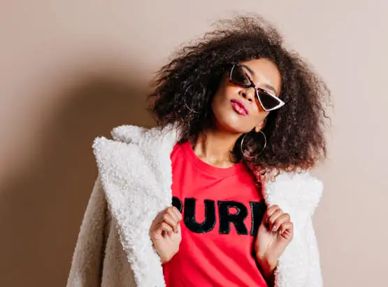 confident good looking curly woman posing in studi
